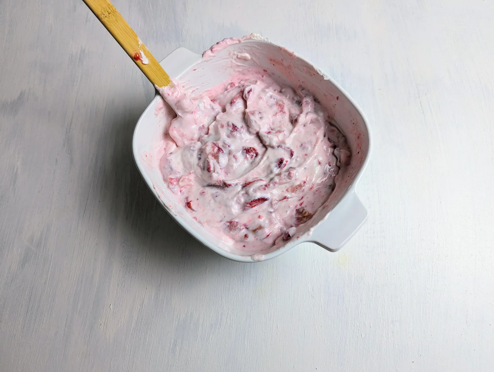 Strawberries and yogurt mixed together in a bowl
