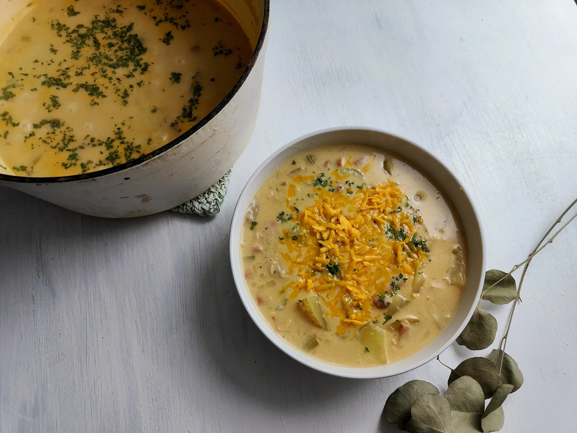 A bowl of potato soup topped with cheese