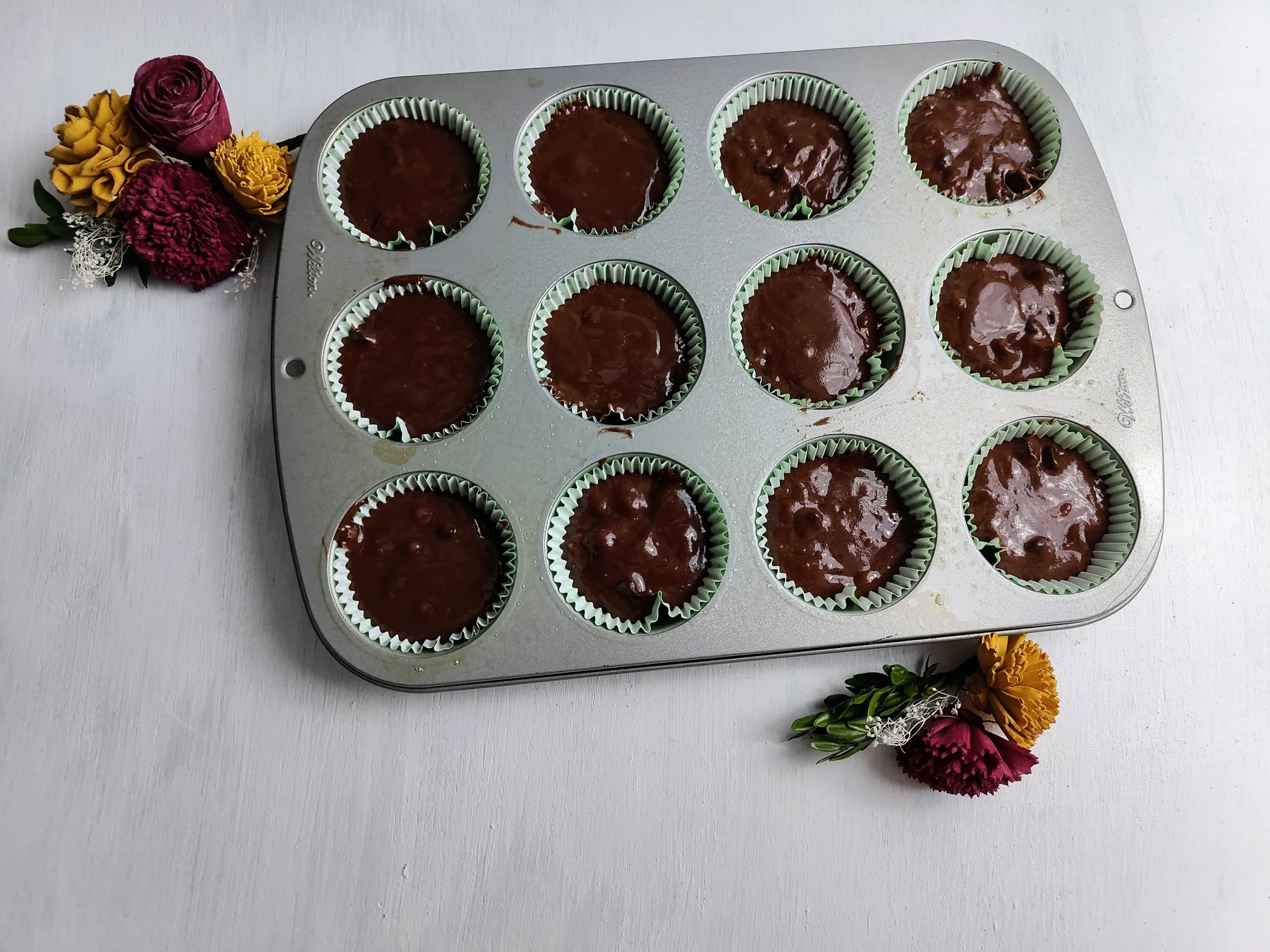A muffin tin filled with chocolate batter