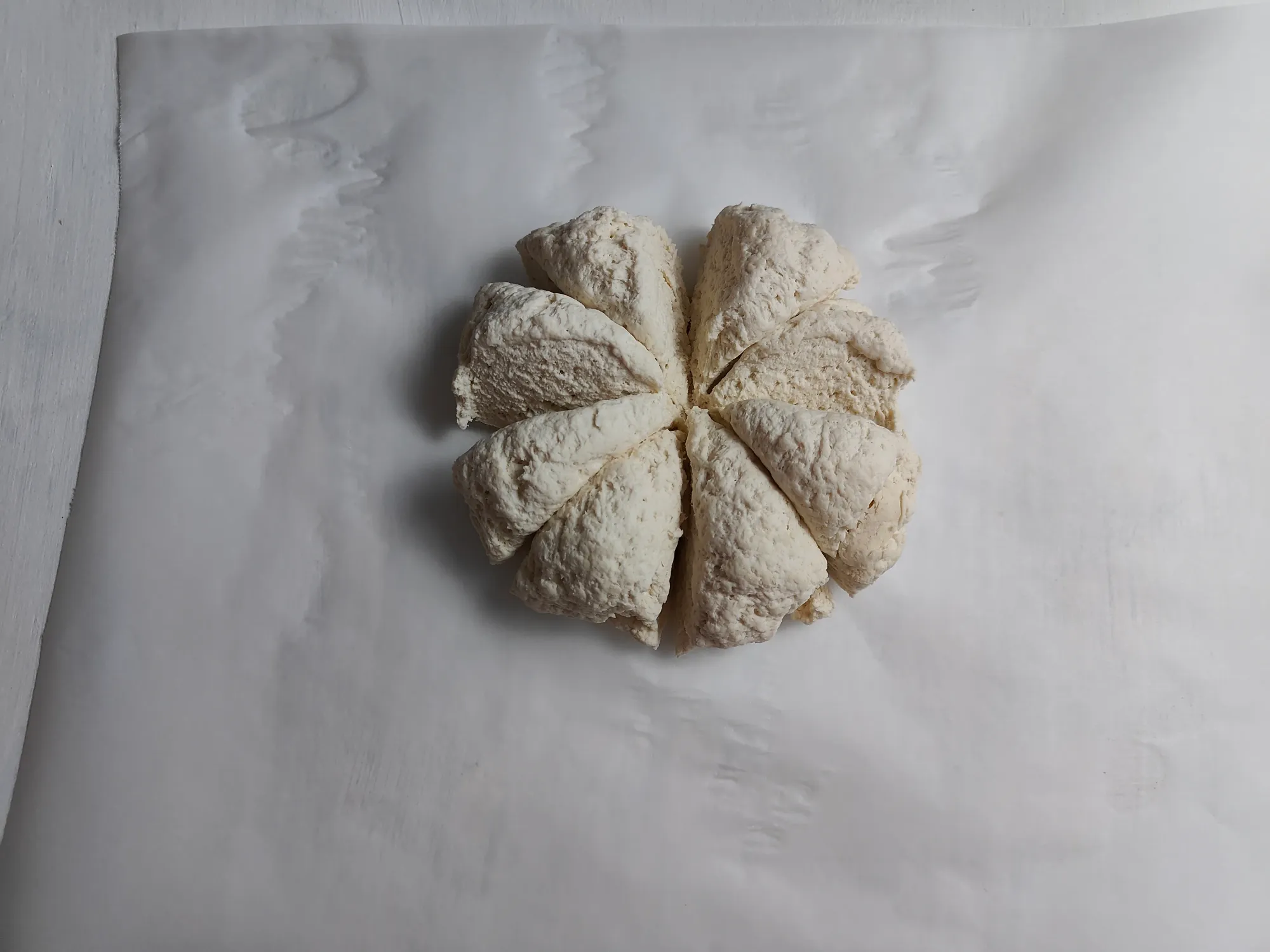 A bread dough ball divided into 8 wedges