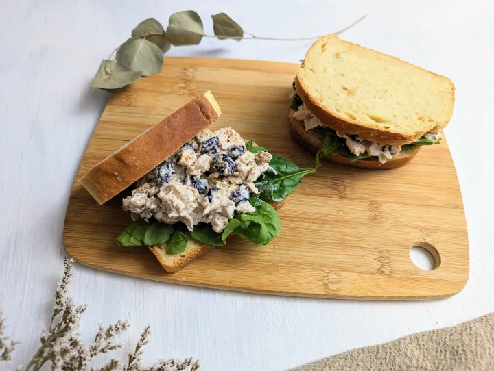 Two chicken salad sandwiches on a cutting board